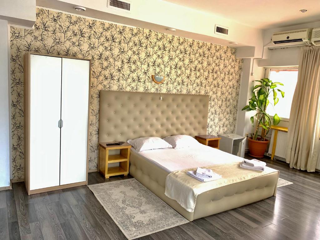 um quarto com uma cama grande e uma parede em Hotel Funnytime em Bucareste