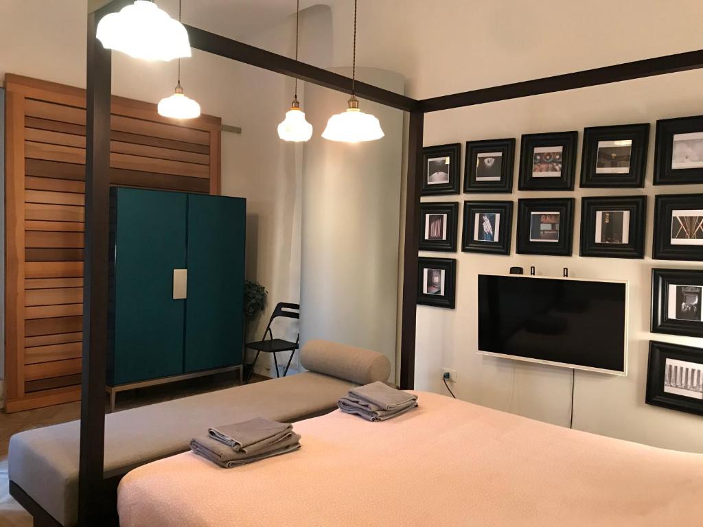 a bedroom with a bed and a flat screen tv at The Butcher-Ducati and Airport BLQ in Bologna
