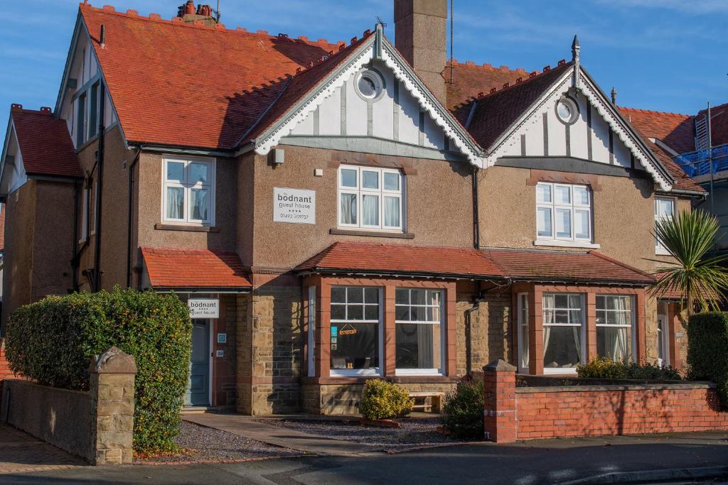 a large brick house with a red roof at Bodnant Guest House in Llandudno