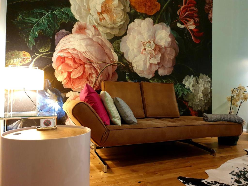 sala de estar con sofá y un mural de flores en Apartment P1 in Berlin-Friedrichshain, en Berlín