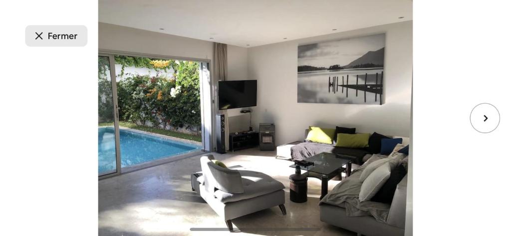 a living room with a couch and a swimming pool at Villa moderne avec piscine, front de mer in Casablanca