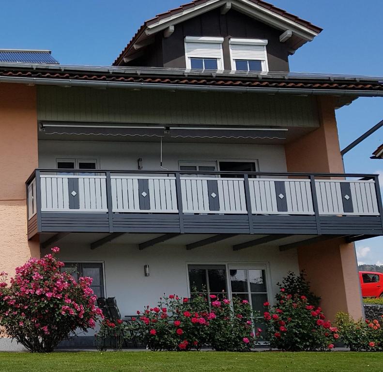a house with a balcony with flowers on it at Ferienwohnung Breit in Kirchdorf im Wald