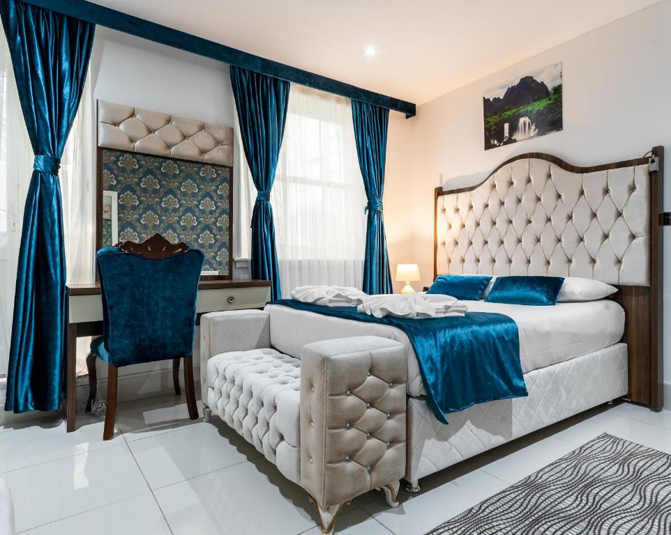 1 dormitorio con cama, silla y escritorio en Vilenza Hotel en Londres