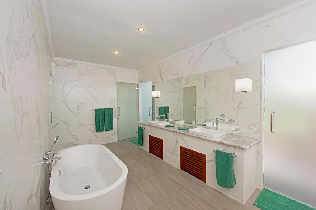 a bathroom with a large tub and a sink and a bath tub at Thulhagiri Island Resort & Spa in North Male Atoll
