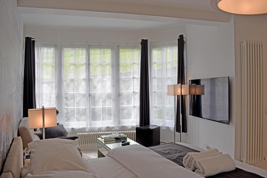 a living room with two beds and a large window at Villa Castel Chambres d'hôtes B&B in Dieppe