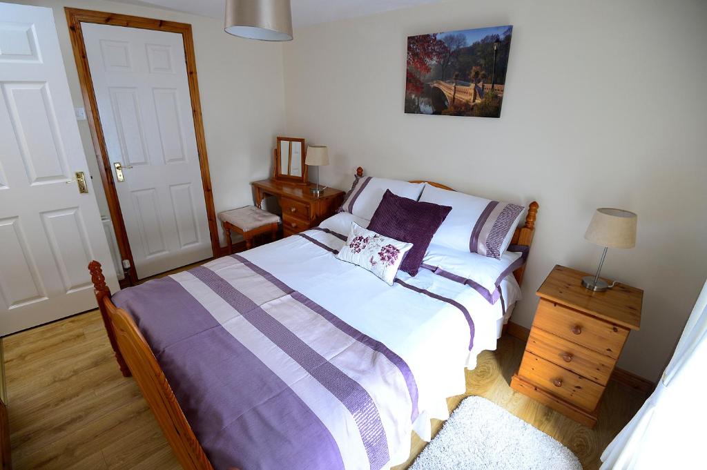 A bed or beds in a room at Village Cottage Bushmills