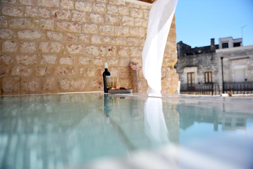 a bottle of wine sitting on the floor of a swimming pool at Arya Nobile Dimora in Carovigno