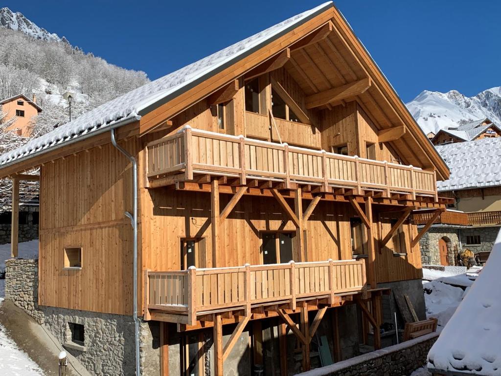 a large wooden house with two decks in the snow at VAUJANYLOCATIONS - Chalet Opaline in Vaujany