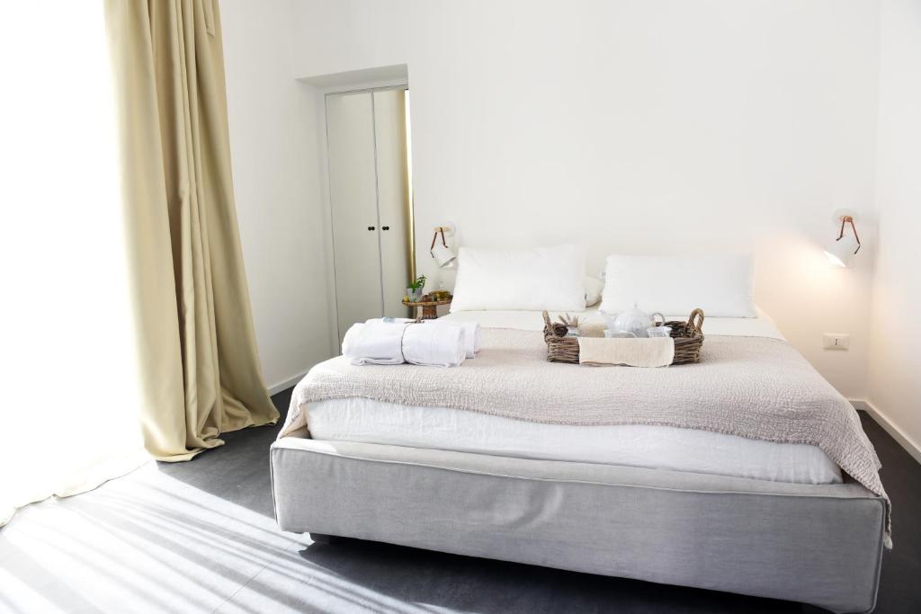 a bedroom with a large bed with two baskets on it at Arya Nobile Dimora in Carovigno