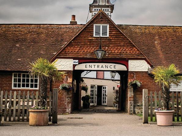 an entrance to a brick building with a clock tower at The Walhampton Arms in Lymington