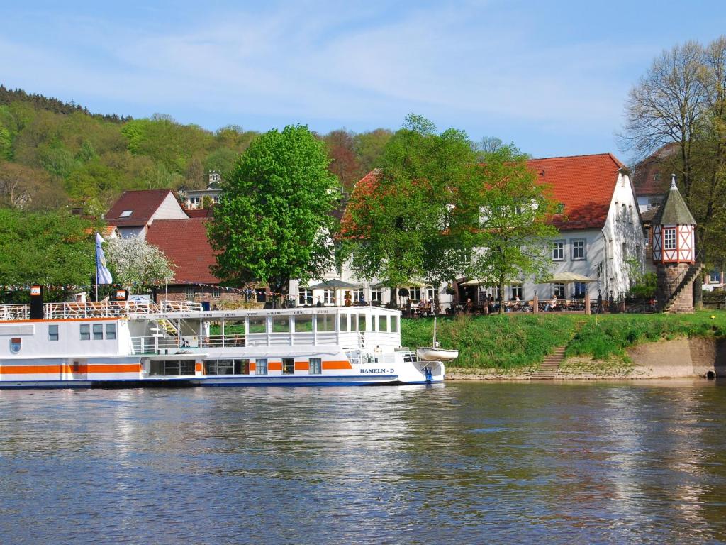 a boat is docked on the river in a town at Zum Weserdampfschiff in Bad Karlshafen