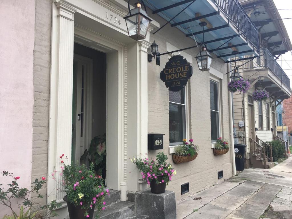 uma loja em frente a uma casa com flores na porta em WG Creole House 1850 em Nova Orleans