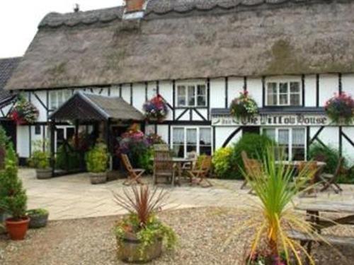 una casa con tetto di paglia e patio di The Willow House a Watton