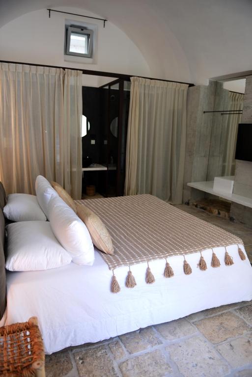 a bed with pillows on it in a room at Arya Nobile Dimora in Carovigno