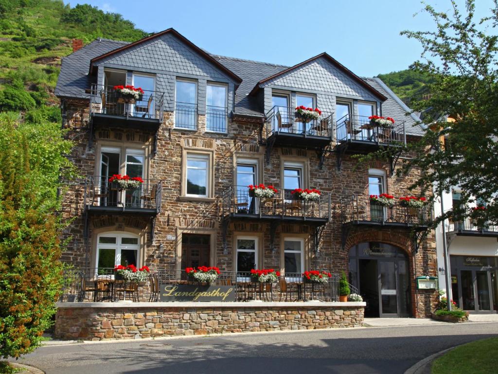 a brick house with flower boxes on the balconies at Landgasthof Winzerscheune in Valwig