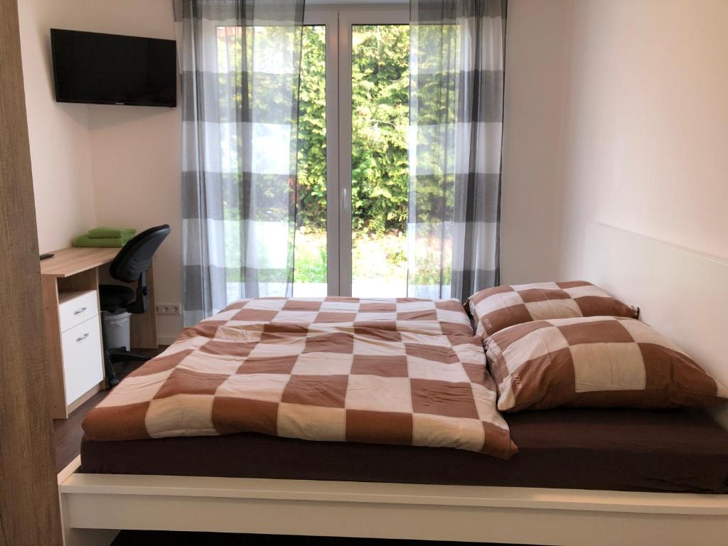a bedroom with a bed with a window and a desk at Gästehaus Witteborg in Paderborn