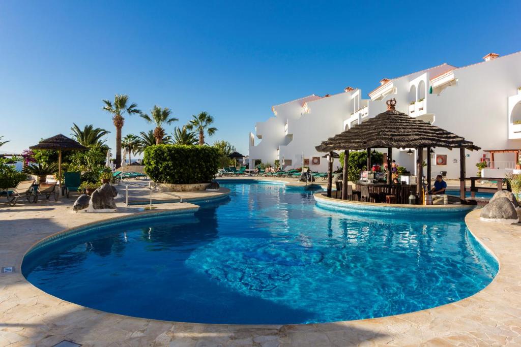 una piscina en un complejo con agua azul en Regency Torviscas Apartments and Suites en Adeje