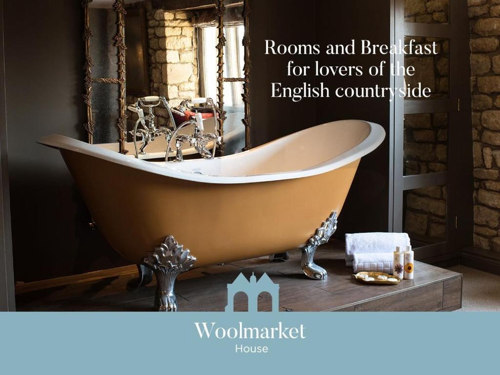 a bathroom with a bath tub on a table at Woolmarket House in Chipping Campden