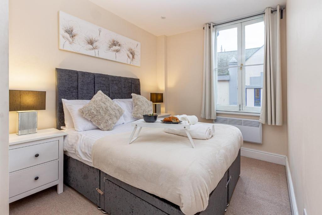 a bedroom with a large bed with a table on it at Guest Homes - Trinity Flat in Worcester
