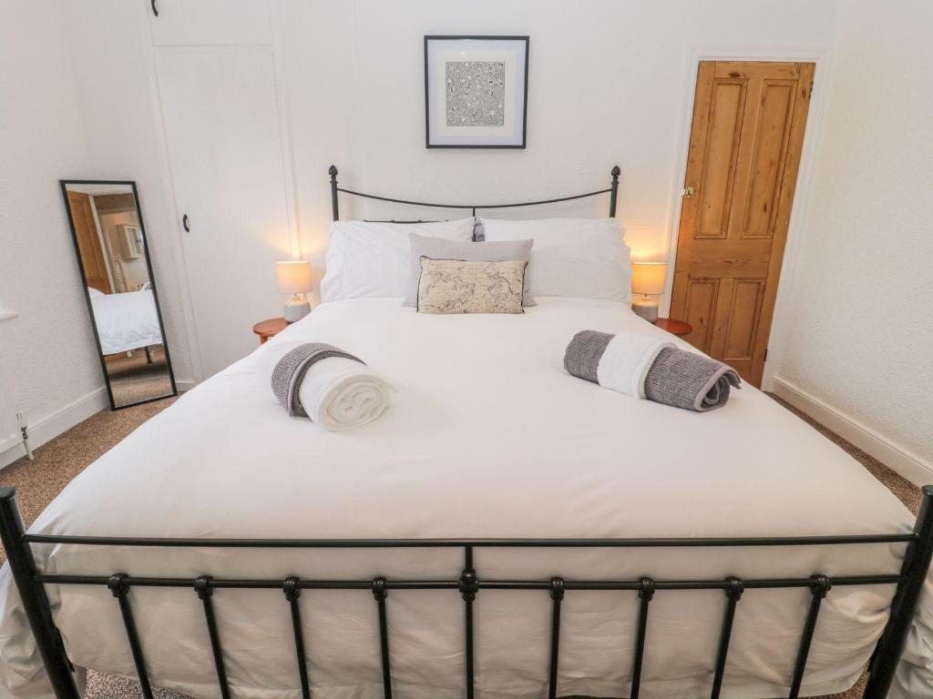 a bedroom with a large white bed with two pillows at Cheviot Way Cottage in Wooler
