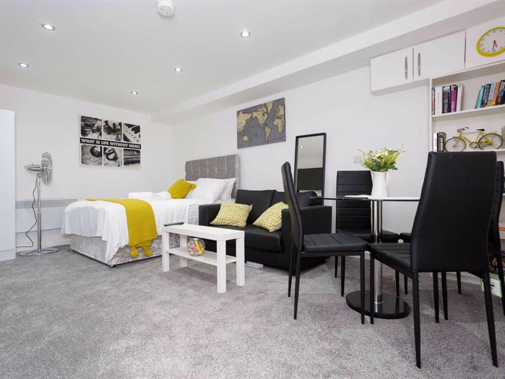 a bedroom with a bed and a table and chairs at Berkley Studio in Leeds