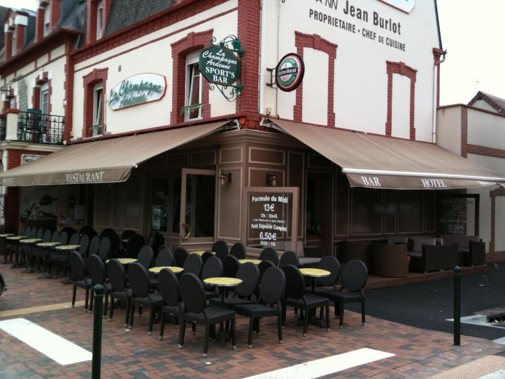 eine Reihe von Tischen und Stühlen außerhalb eines Gebäudes in der Unterkunft Hôtel La Champagne Ardenne Cabourg in Cabourg