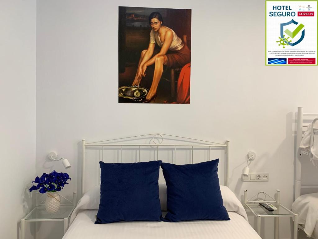 1 dormitorio con 1 cama con una pintura en la pared en Belmonte Rooms, en Córdoba