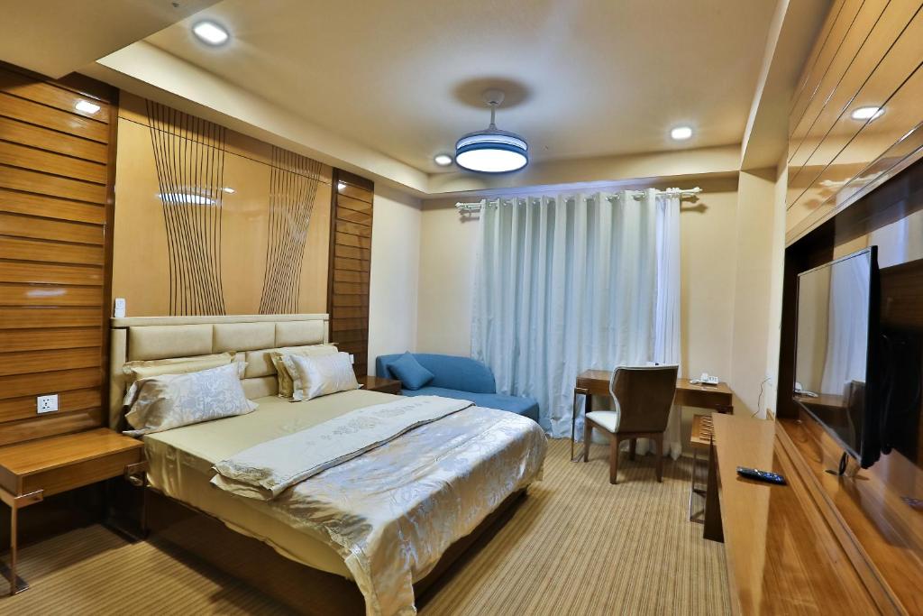a hotel room with a bed and a television at Hotel Fun Residency by Antra Group in Ahmedabad