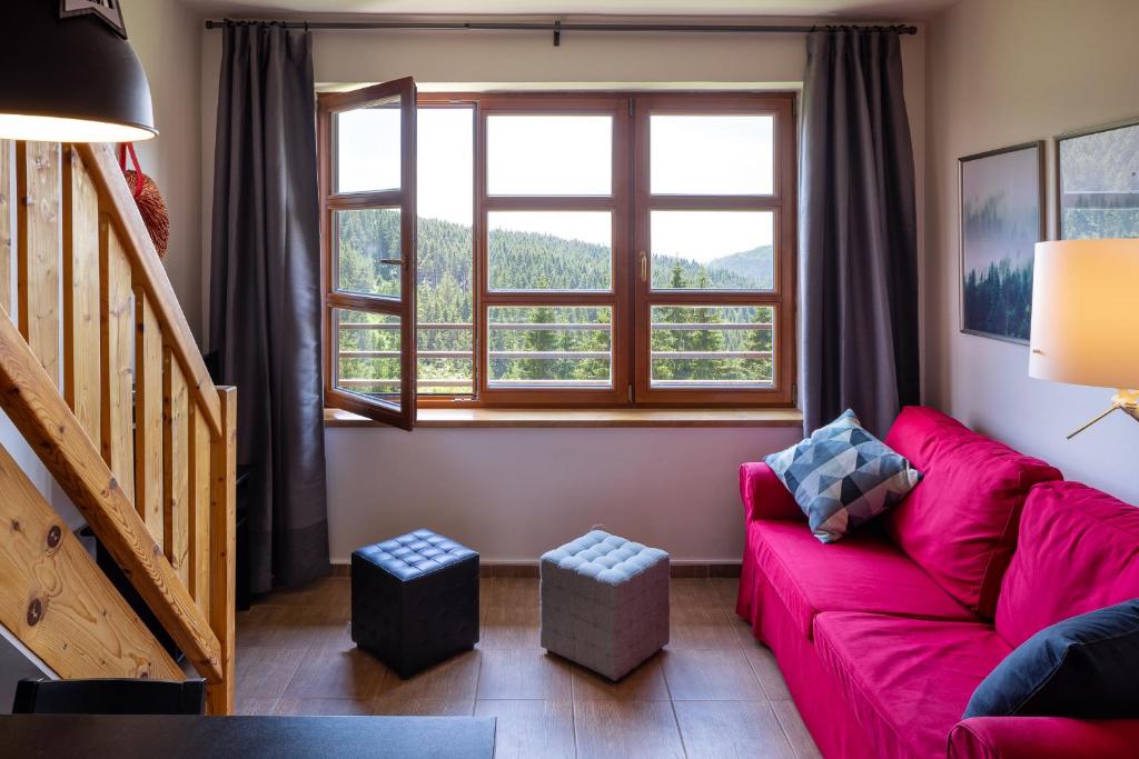 un soggiorno con divano rosso e finestra di Cihlářka 303 a Pec pod Snezkou