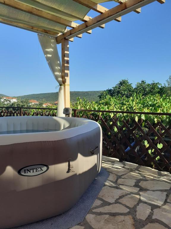 a bath tub sitting under a pergola on a patio at Luminaria Solis kuća za odmor in Rogoznica