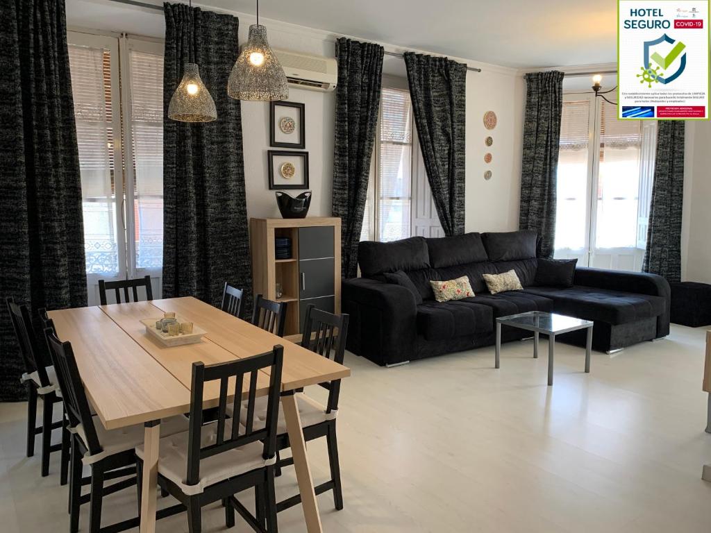 - un salon avec une table et un canapé noir dans l'établissement Corredera Rooms, à Cordoue