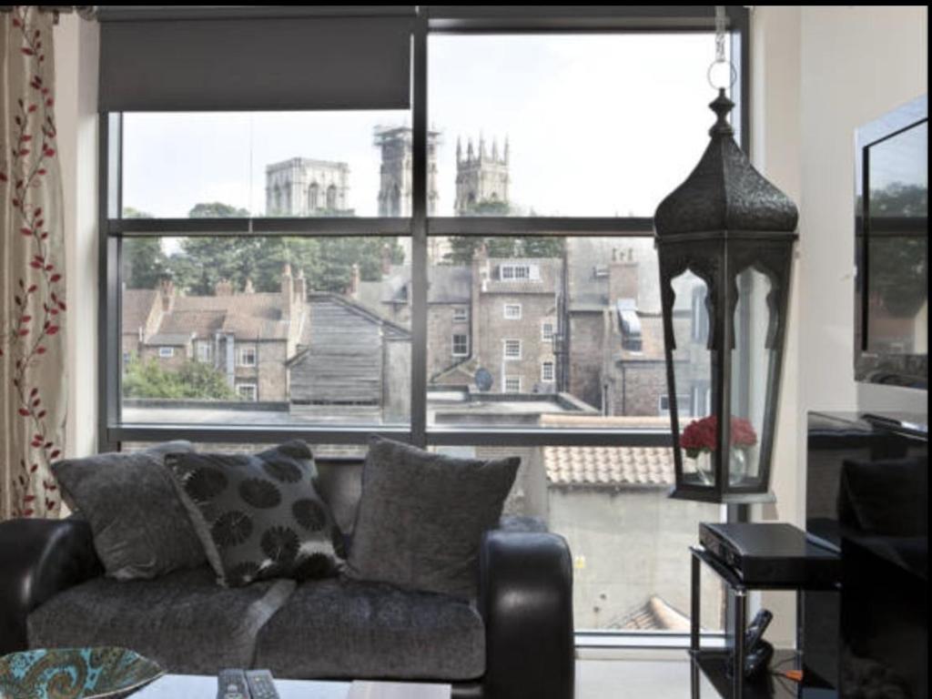 - un salon avec un canapé et une grande fenêtre dans l'établissement Churchill Two Bedroom Apartments with Free Parking and The Minster view, à York