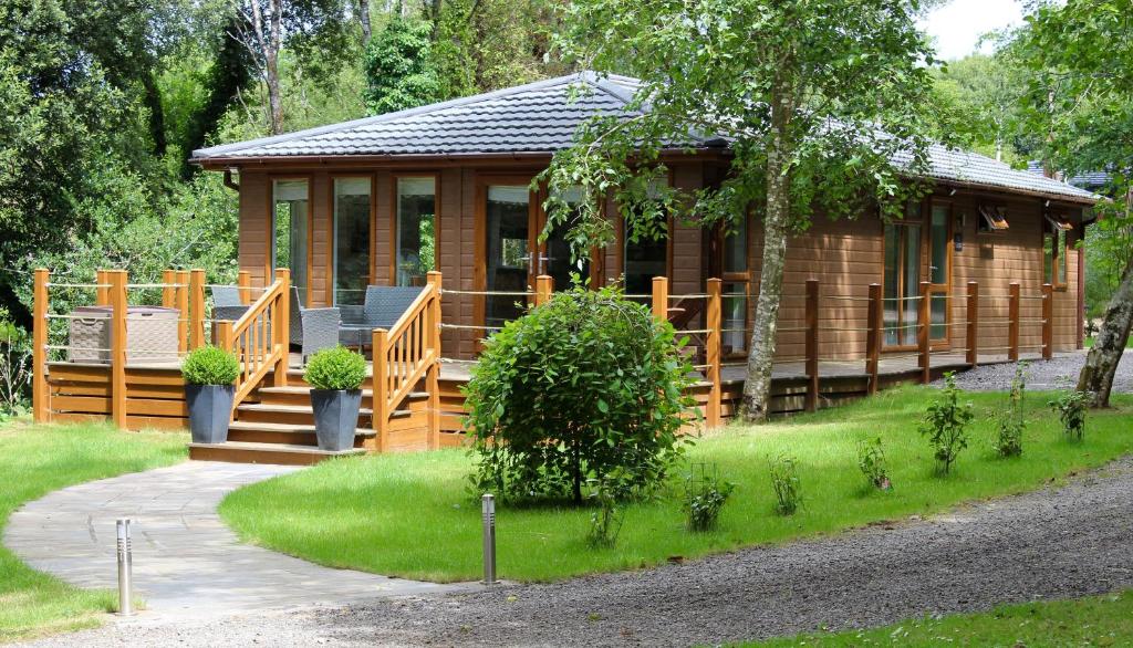 a wooden cabin with a porch and a walk way to it at Chycara in Truro