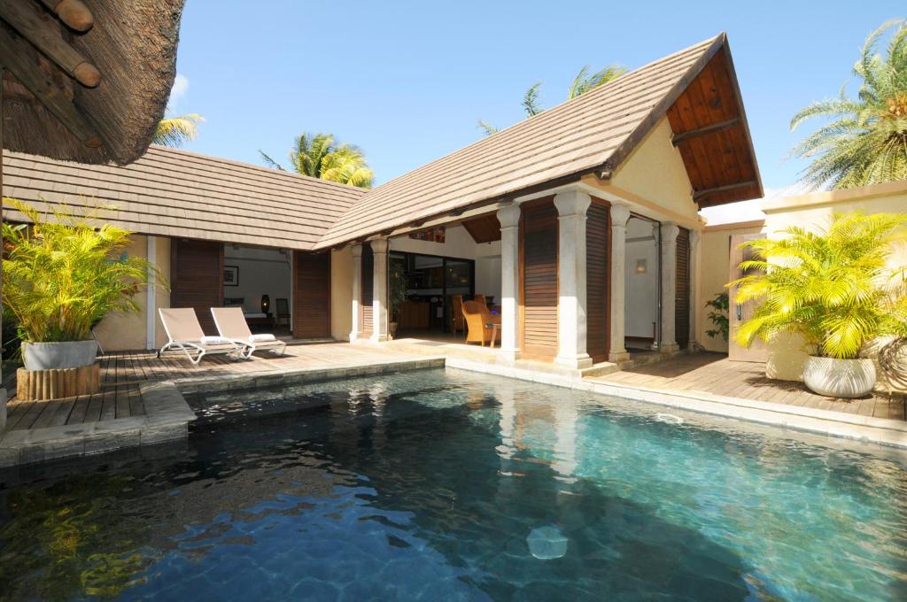 a house with a swimming pool in front of a house at Villa Oasis in Pereybere