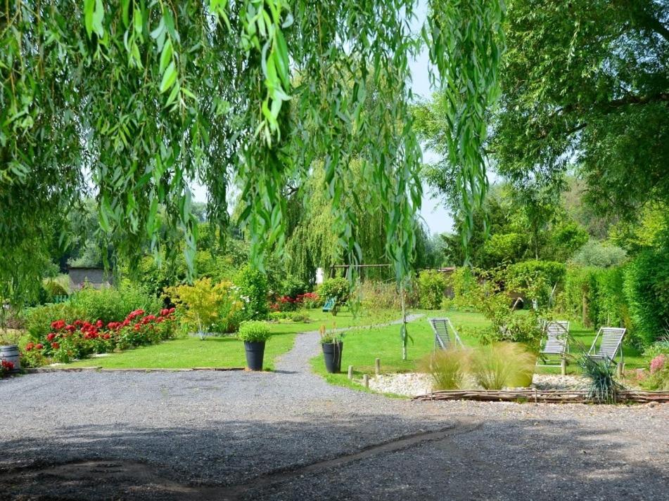 a park with benches and flowers and a tree at Cléome in Arques-la-Bataille