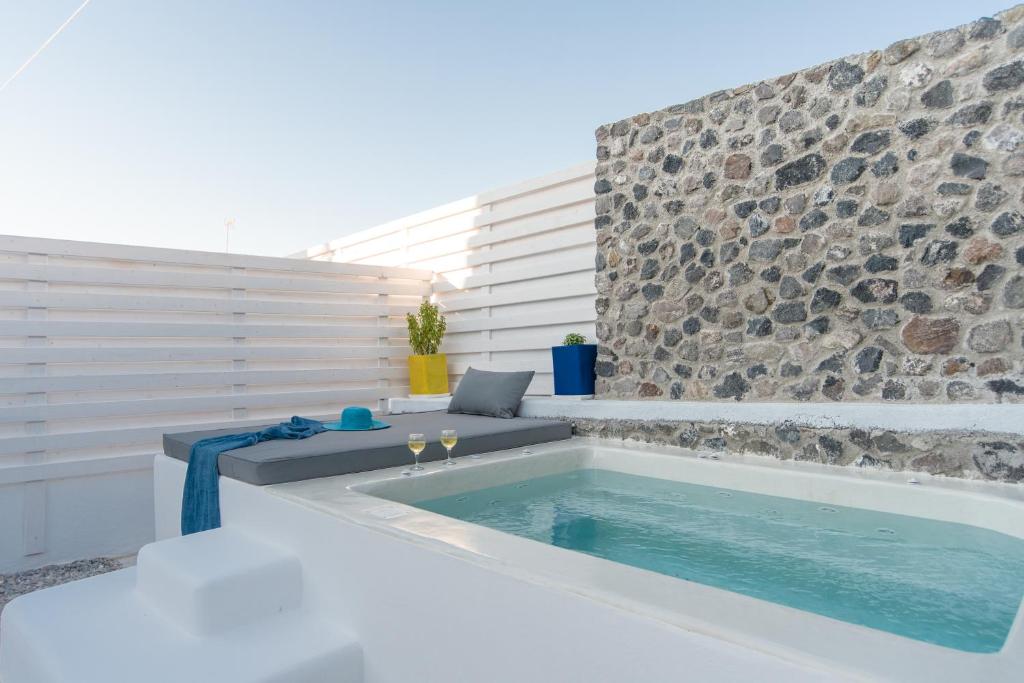 a swimming pool with a bench next to a stone wall at LAGADI SUITES by K&K in Mesaria