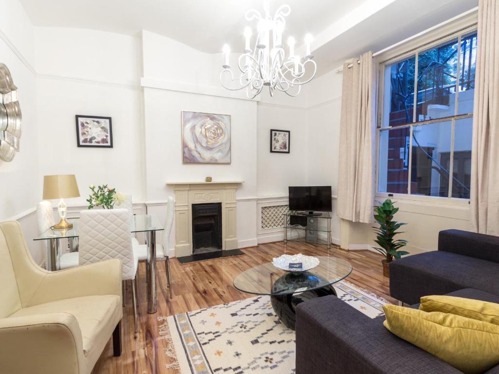 sala de estar con sofá y chimenea en Comfortable One Bed in Central, en Londres