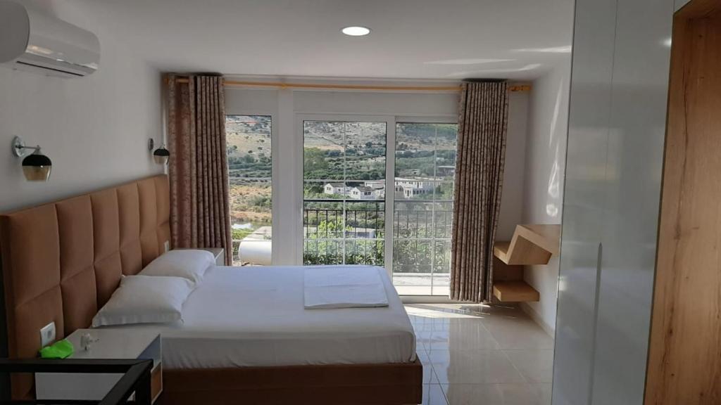 una camera con un letto e una grande finestra di Vila SUN 2E a Ksamil