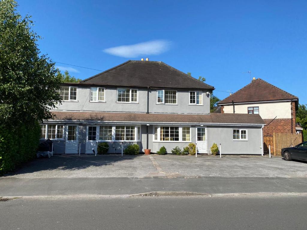 uma grande casa branca com muitas janelas em Cranmore Guest House em Solihull