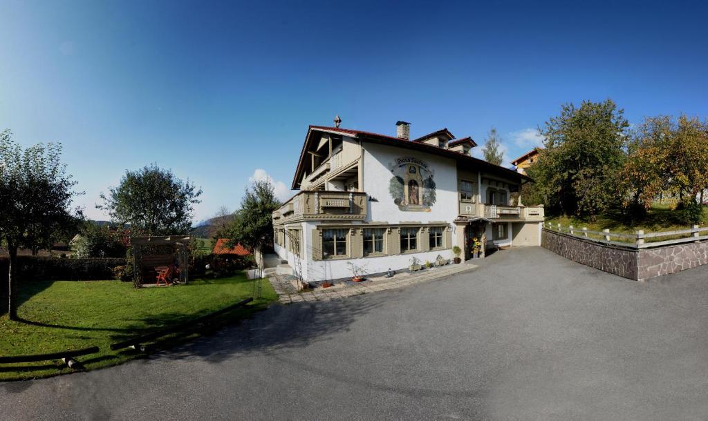 une grande maison blanche avec une grande allée. dans l'établissement Haus Leutner, à Bodenmais