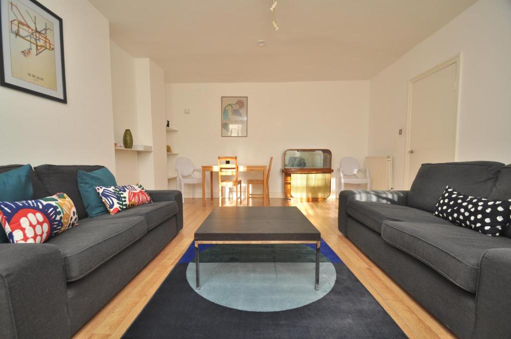 a living room with two couches and a coffee table at Large Garden flat in the heart of Islington in London