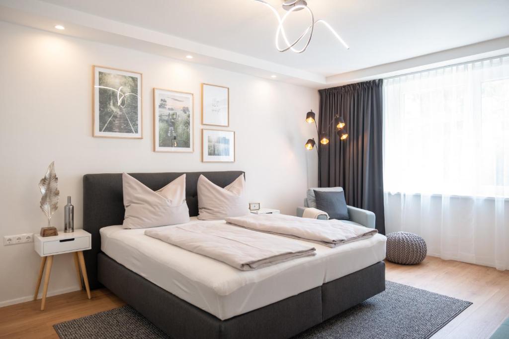 a bedroom with a large bed and a chair at MH Living - 5 - Scandinavian Living Dream in Center in Graz