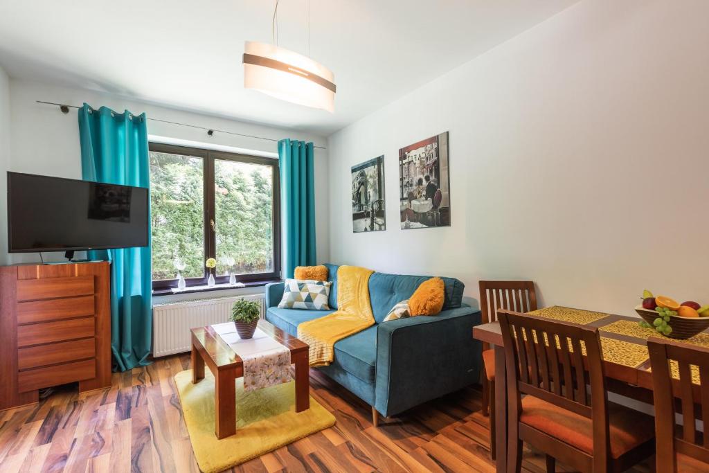 a living room with a blue couch and a table at Apartament Olivia Zakopane in Zakopane