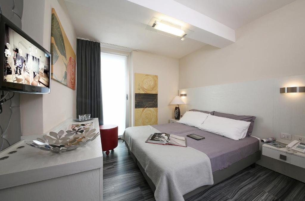 Postel nebo postele na pokoji v ubytování Happy Hotel Atelier Gardone Riviera Centro & Beach
