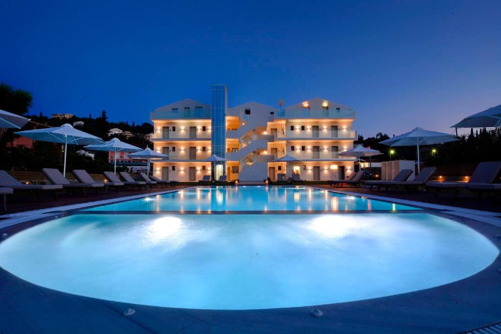 uma grande piscina em frente a um hotel à noite em V Luxury Suites em (( Agía Eleoúsa ))