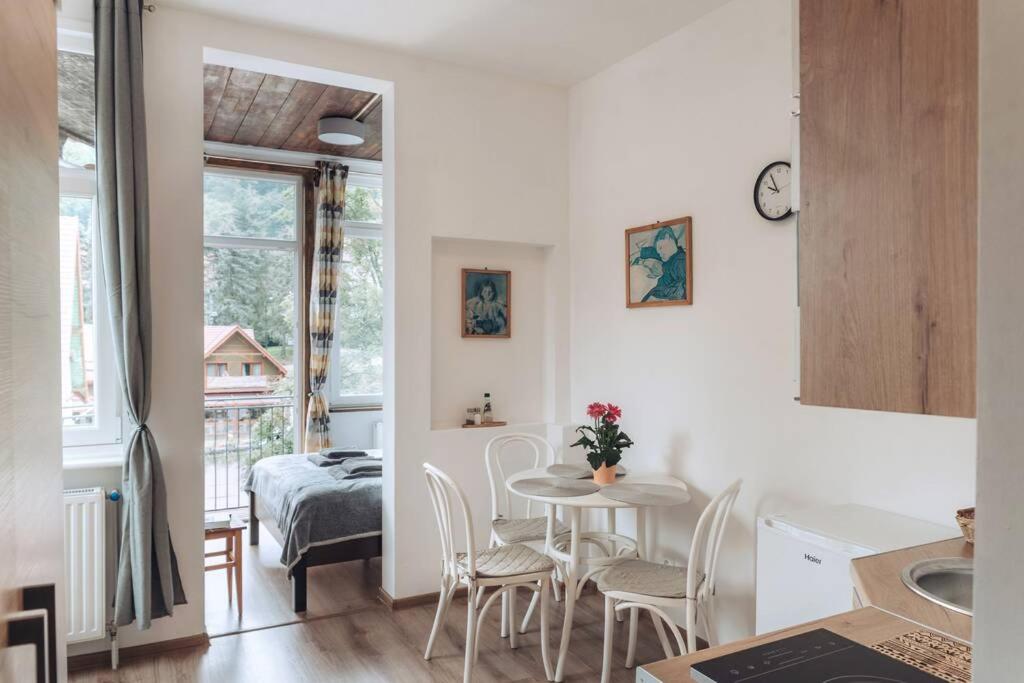 a kitchen and dining room with a table and chairs at Duszniki-Zdrój Przytulny Apartament z Tarasem in Duszniki Zdrój