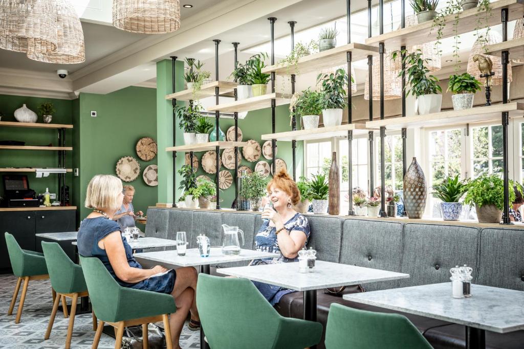 two women sitting at tables in a restaurant at The Marine in Whitstable