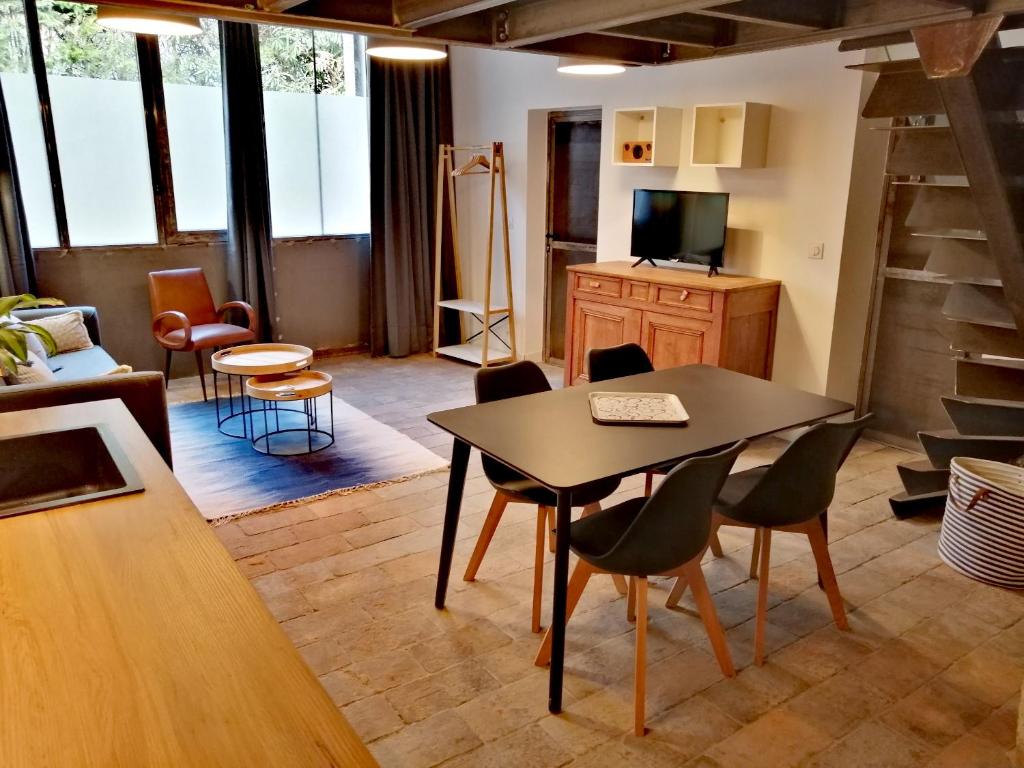 uma sala de estar com mesa e cadeiras em La Maison Grivolas Appartements et Maison d'hôtes em Avignon
