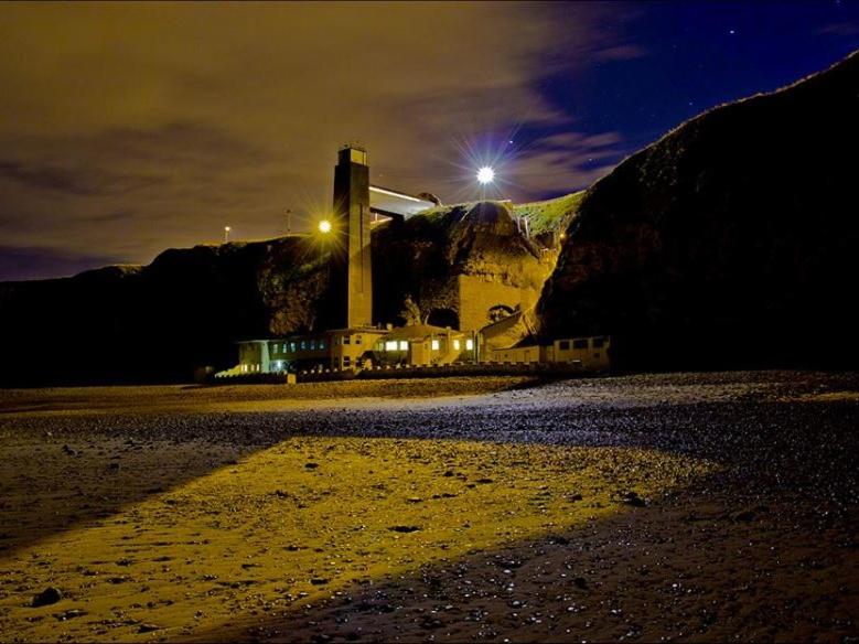 un edificio en la cima de una montaña por la noche en The Grotto, en South Shields