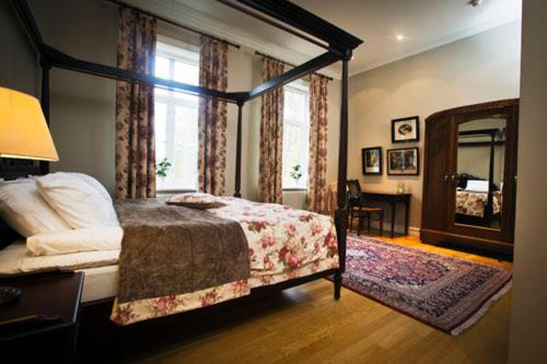 a bedroom with a canopy bed and a mirror at Krokstad Herrgård in Säffle